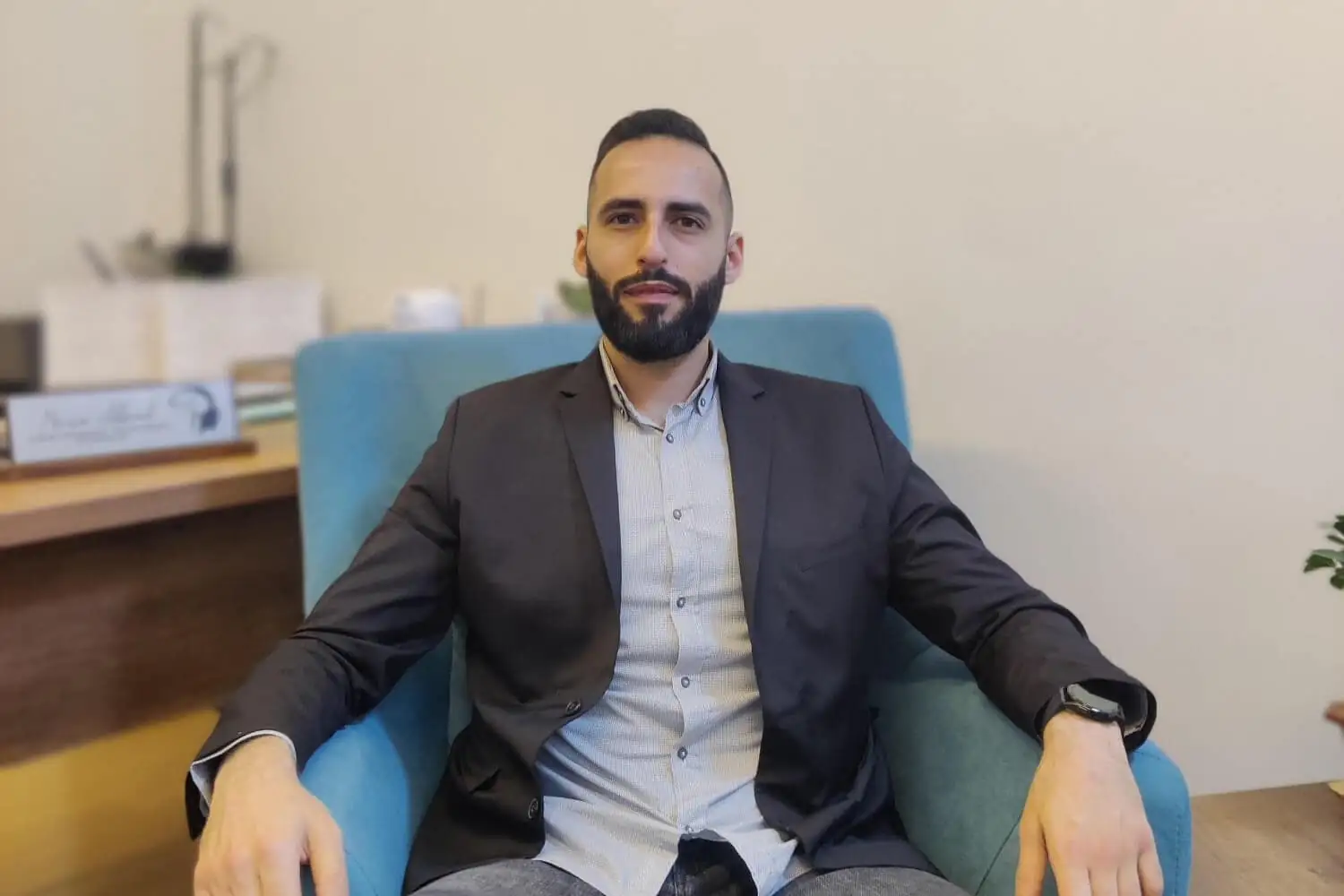 Mario Abboud sitting on a couch in his clinic, creating a welcoming and professional atmosphere.